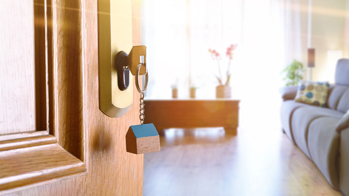 Entrada de casa, porta entreaberta com chave e porta-chave em forma de casa 